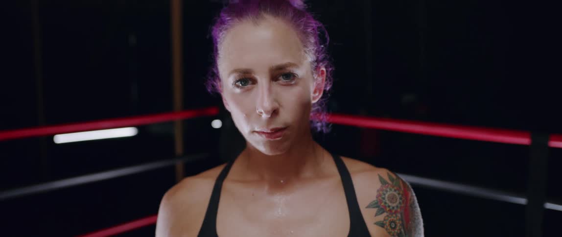 A woman stands in a boxing ring