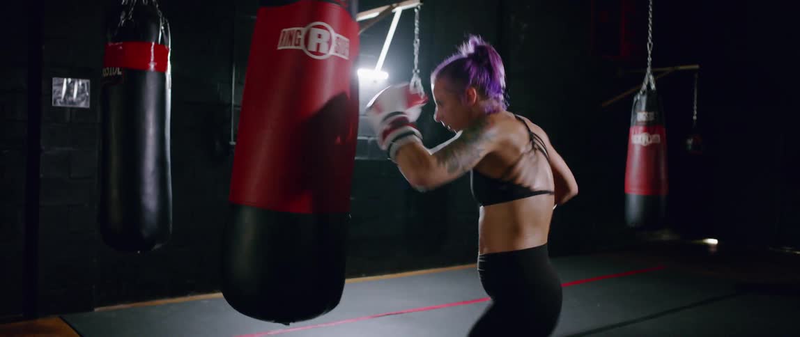 A woman is boxing a heavy bag