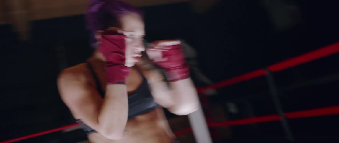 A woman is shadowboxing in the ring