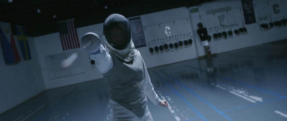 Person poses holding a fencing sword and wearing a uniform