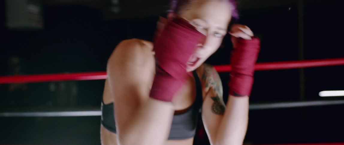 Woman punches and ducks in a boxing ring