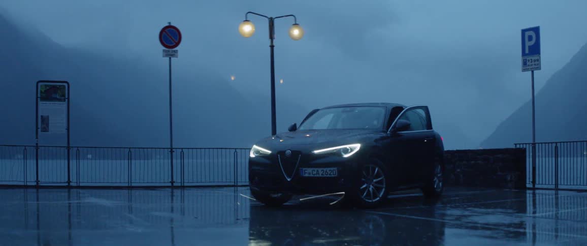 Two women run to a car in the rain