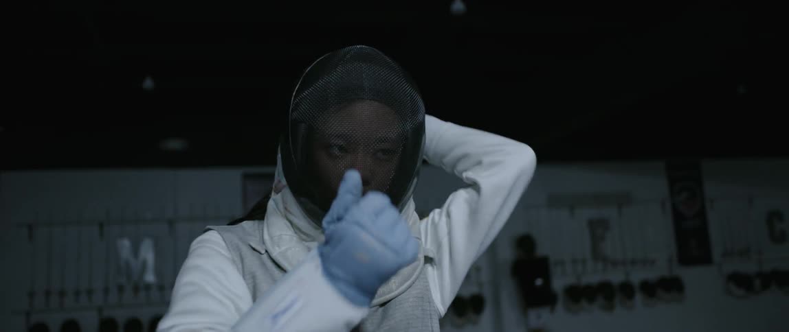 Woman puts on a fencing mask
