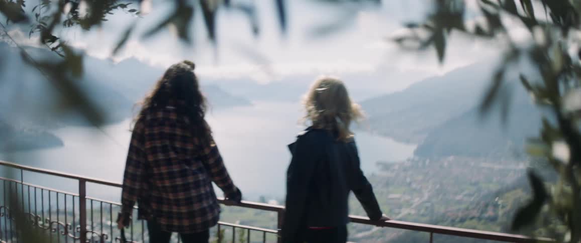 Two women stop to enjoy a lake view