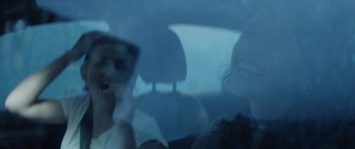 Two women laugh inside the car
