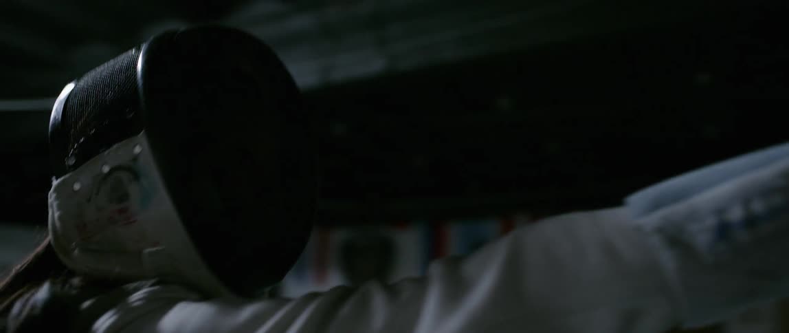 A fencer stabs forward in the gym