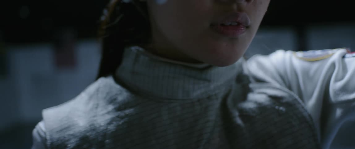 A fencer removes her helmet briefly