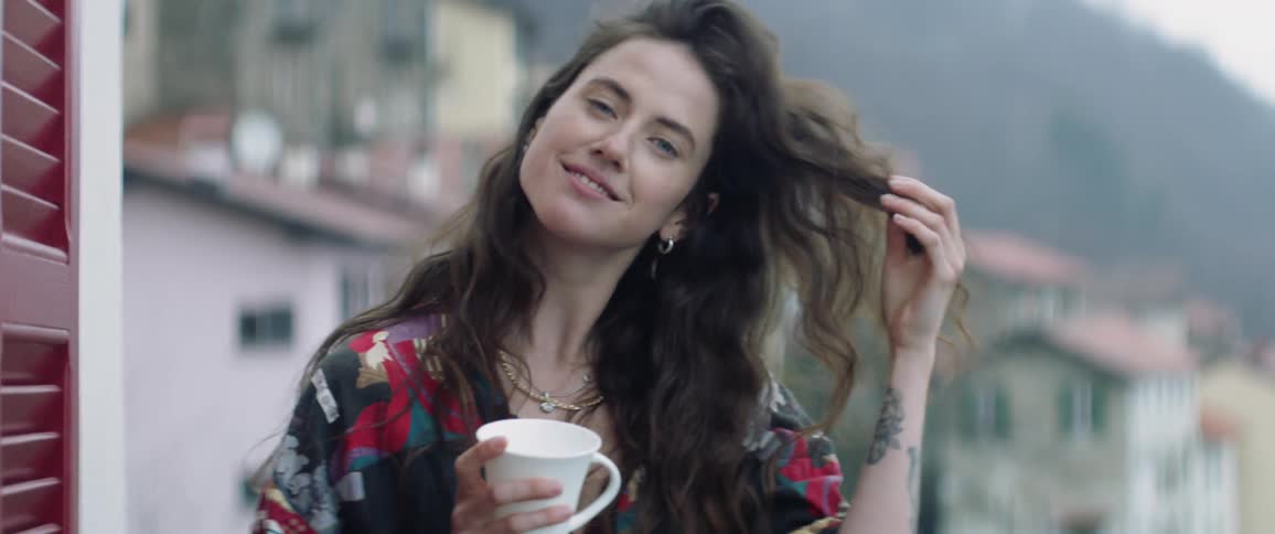 A woman is holding a mug on the roof