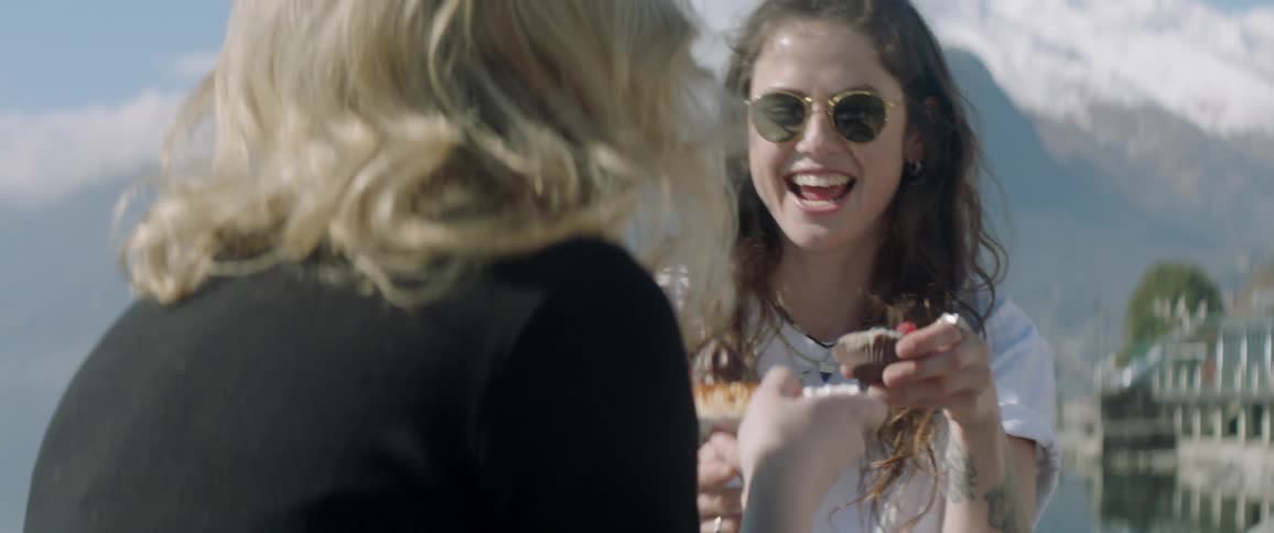A woman is served a cupcake outside