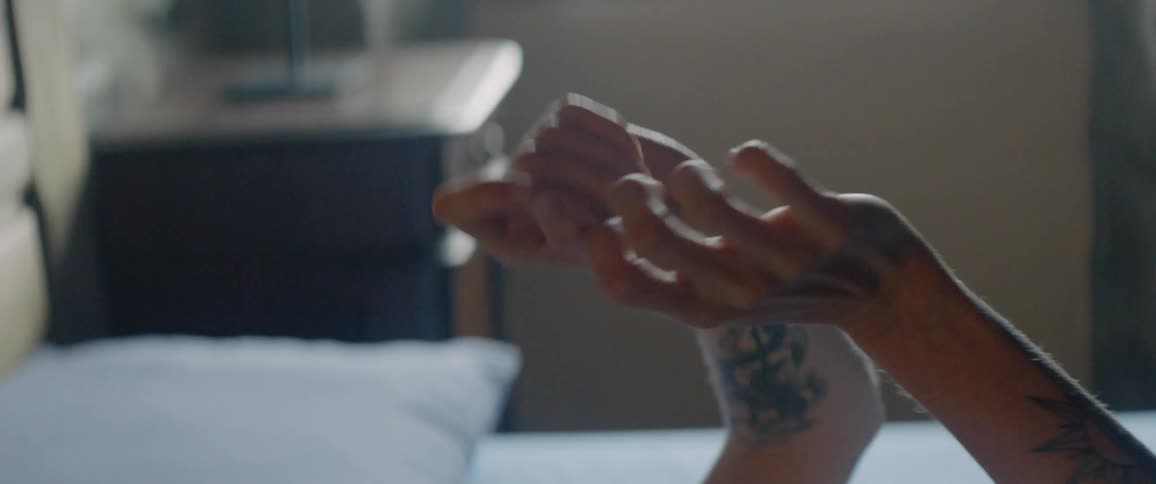 A woman gestures with his arms in bed