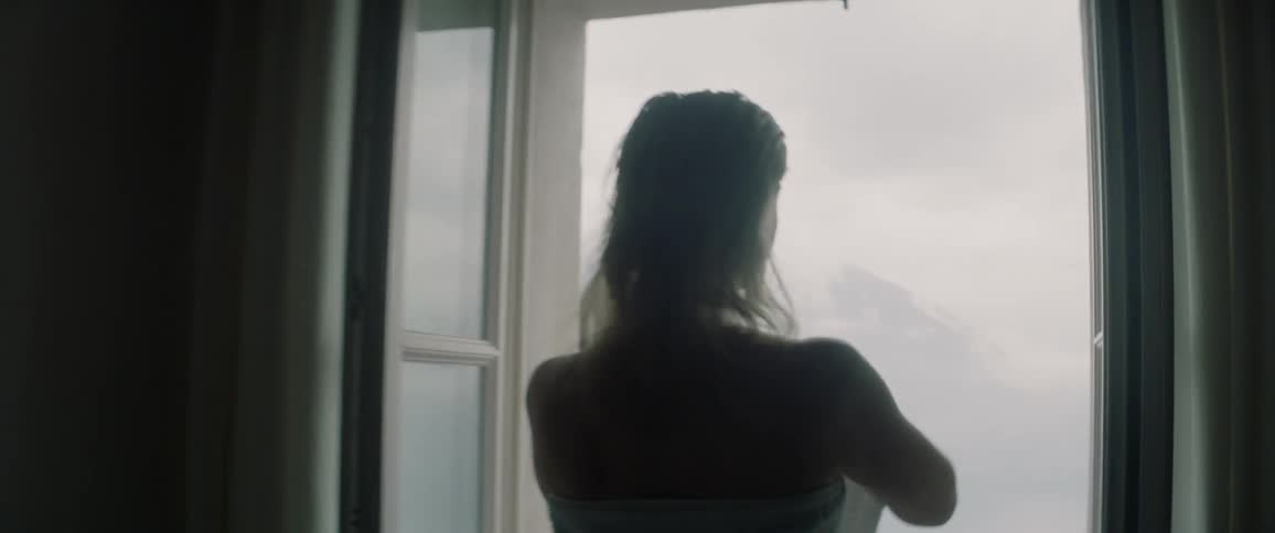 Woman wraps a towel around herself and walks outside