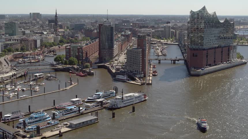 A boat travels on the water away from the city Hamburg