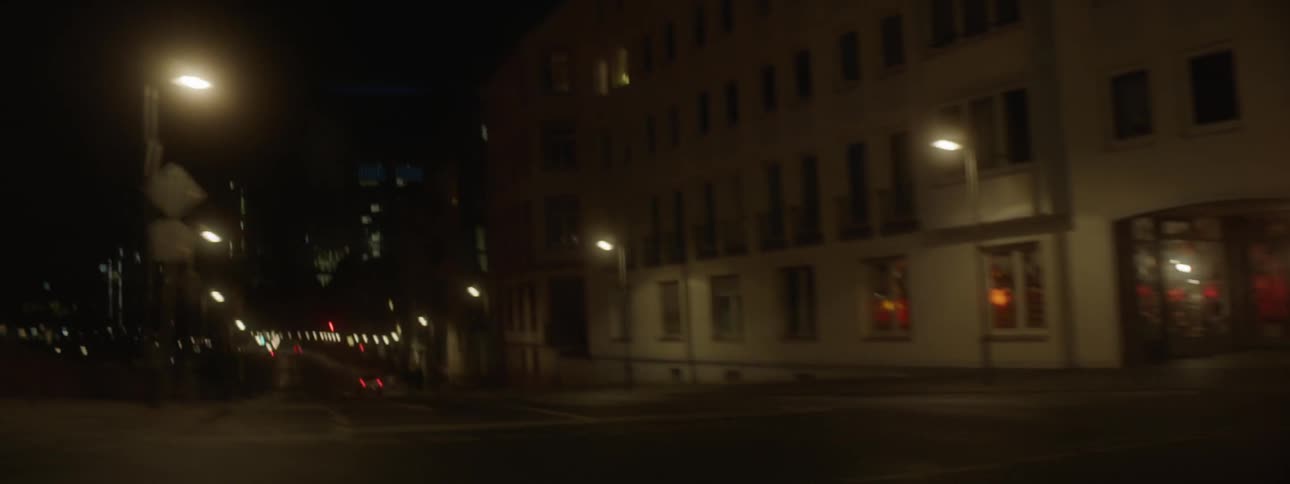 The car moves down the city street at night