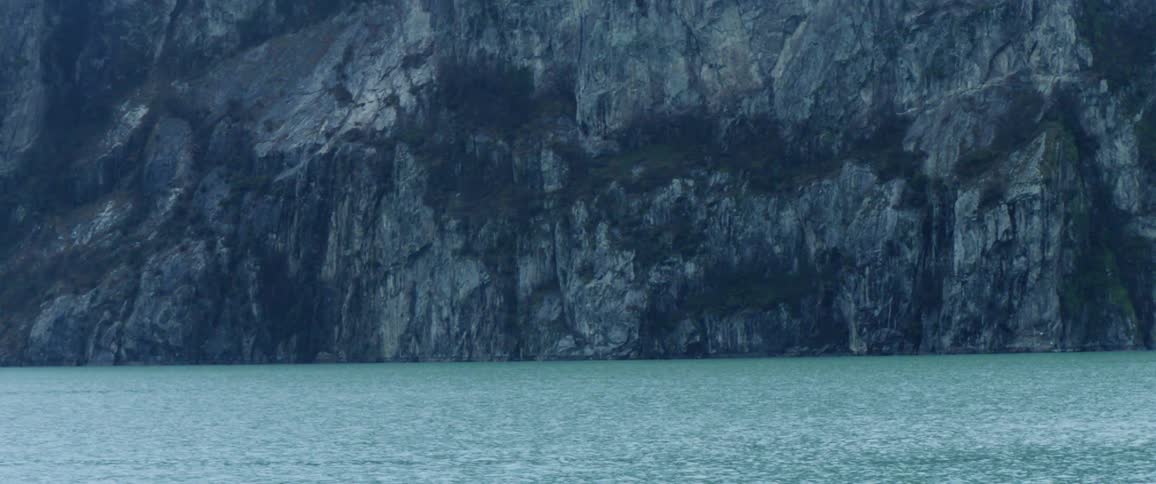 Water flows in front of a large mountain