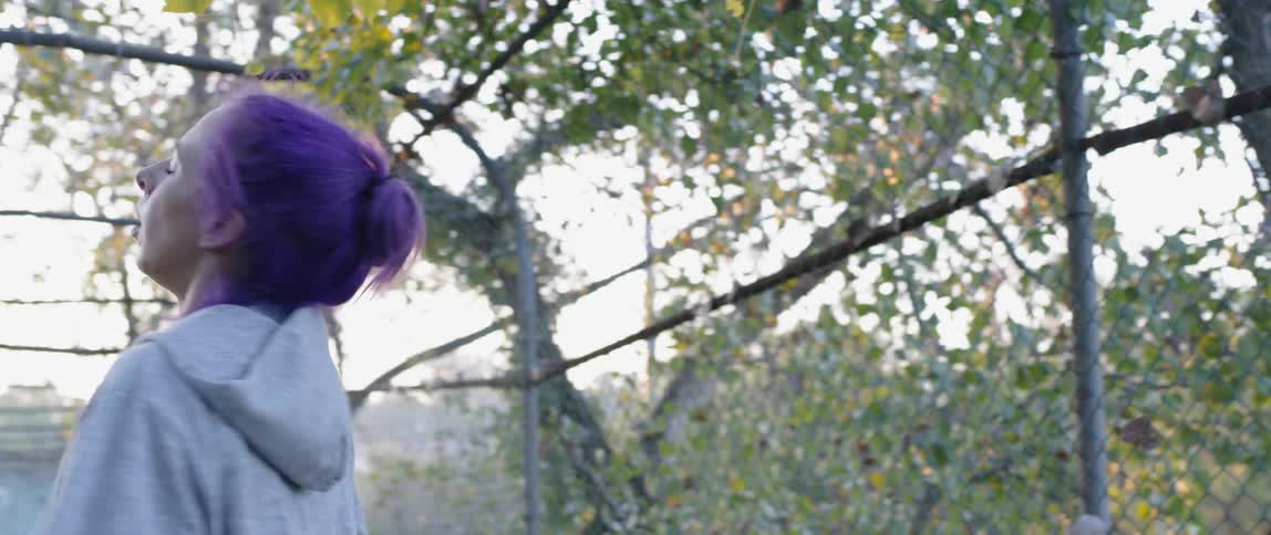A female athlete is bouncing and cooling down on a bridge outside in daylight