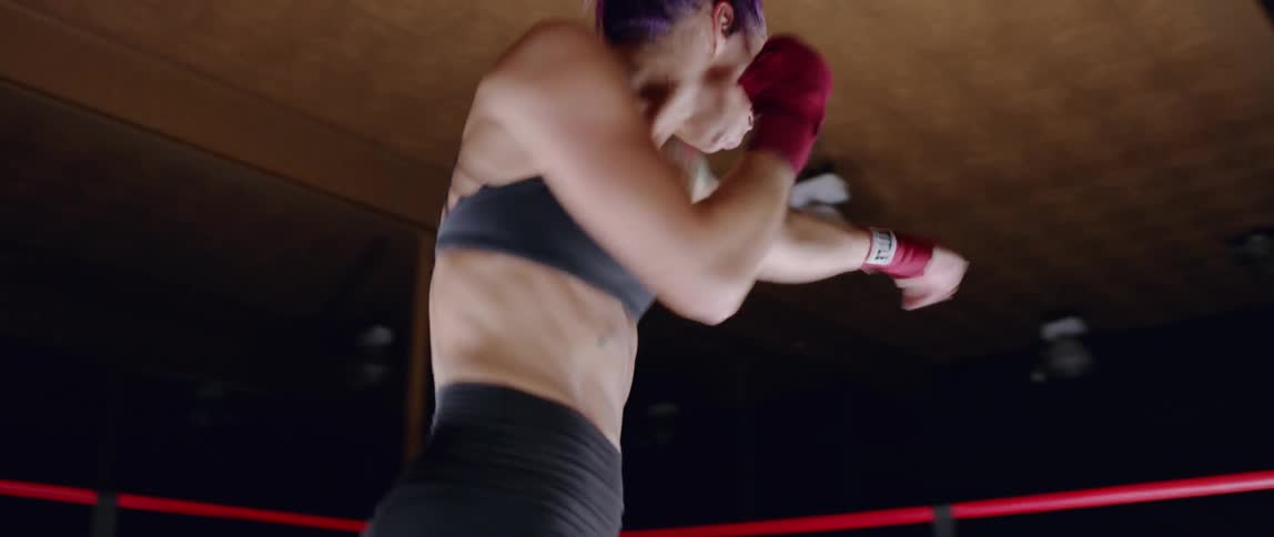 Woman practices punching in a boxing ring