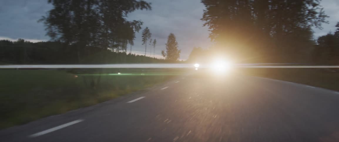 Car driving at night through the forest