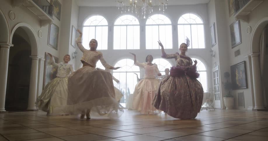 Women dancing in a hall wearing old fashioned dresses