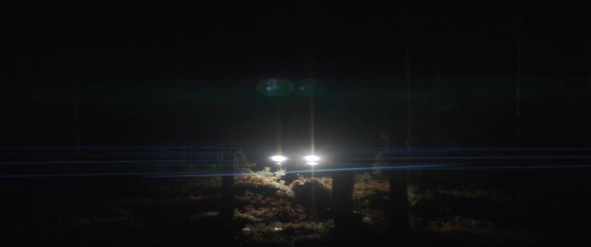 A car is parked up on the hill at night