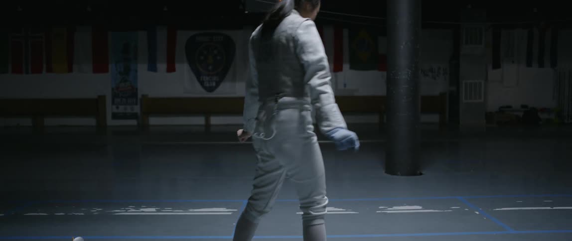 A woman walks around in the dark gym