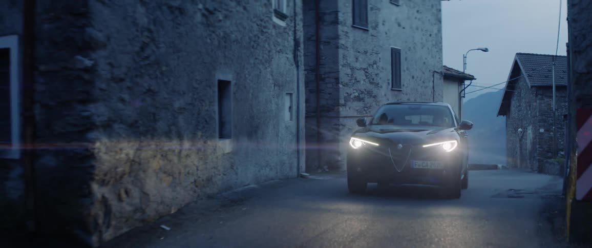 The car turns the corner on the dark street