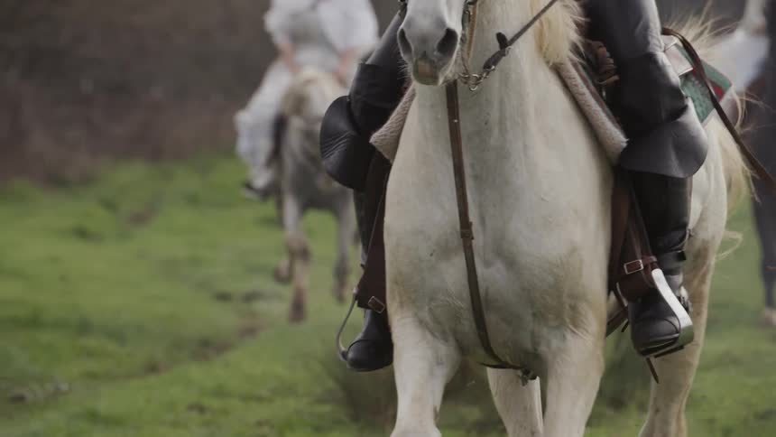 Man and woman in period costumes ride horses
