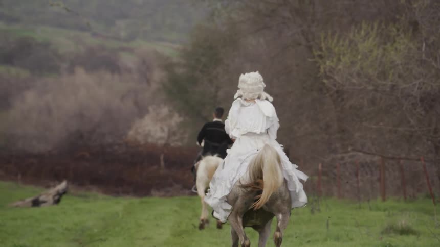 People in white wigs ride on horses