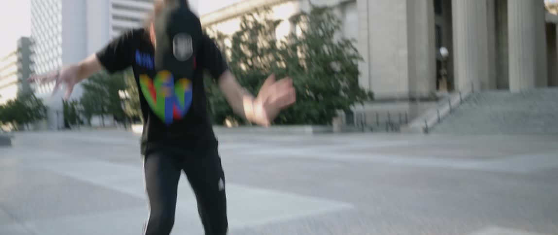 Person dances and spins in a city square