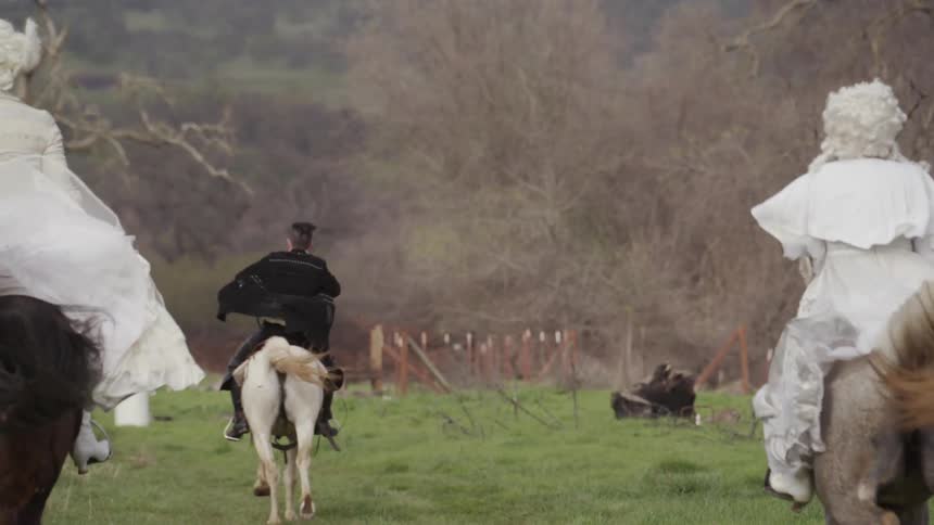 People in victorian era clothes ride horses