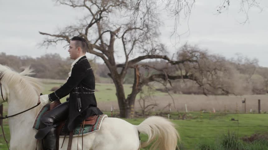 Man and woman in period costumes ride horses