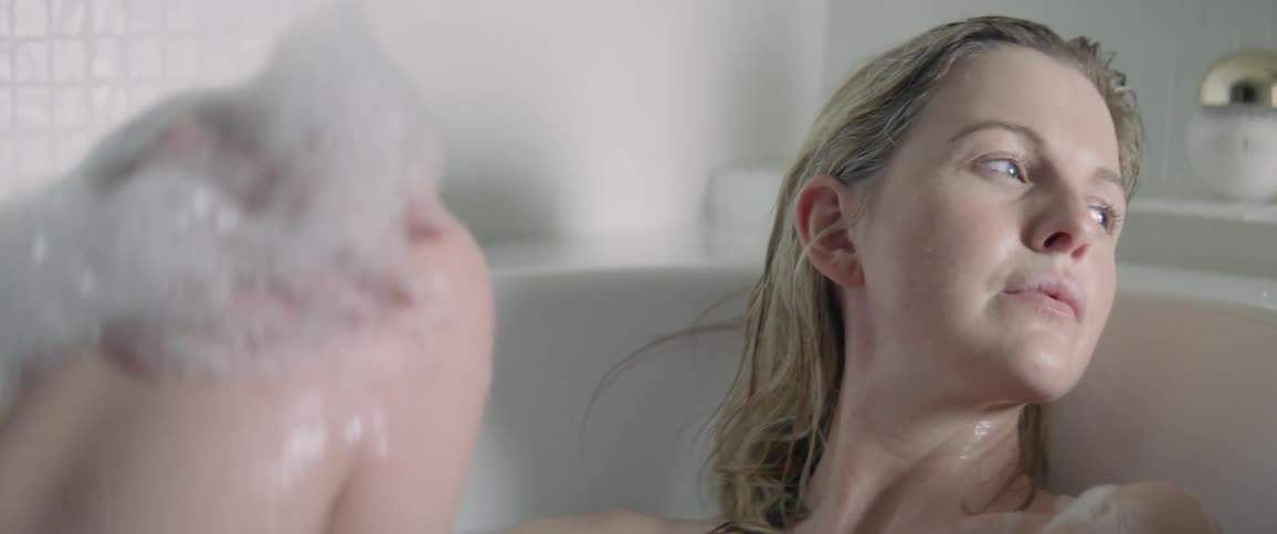 Woman washes her leg in a bathtub