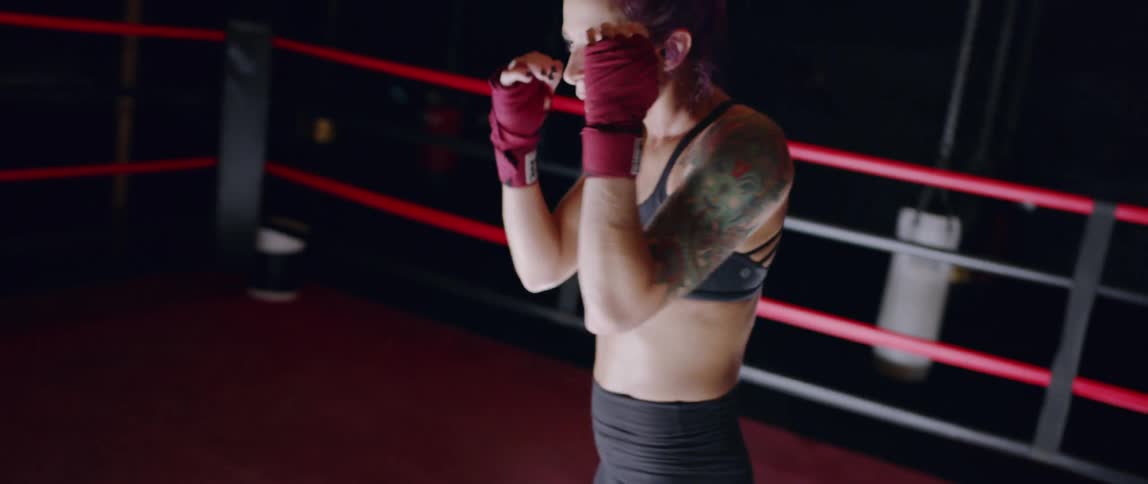 A woman is shadowboxing in the ring