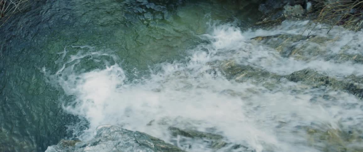 Topdown shot of a waterfall in the mountains