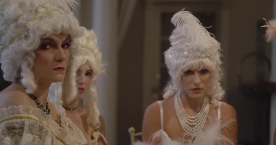 A group of women in white wigs gather