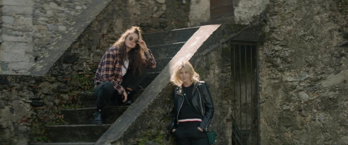 Couple starring at the camera, while standing on old rural stairs
