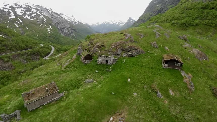An aerial view of a mountainside dotted with homes and a winding road