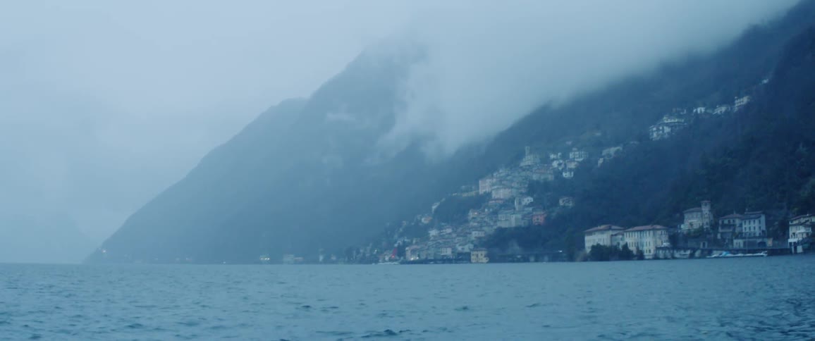 Mountainside near water and fog