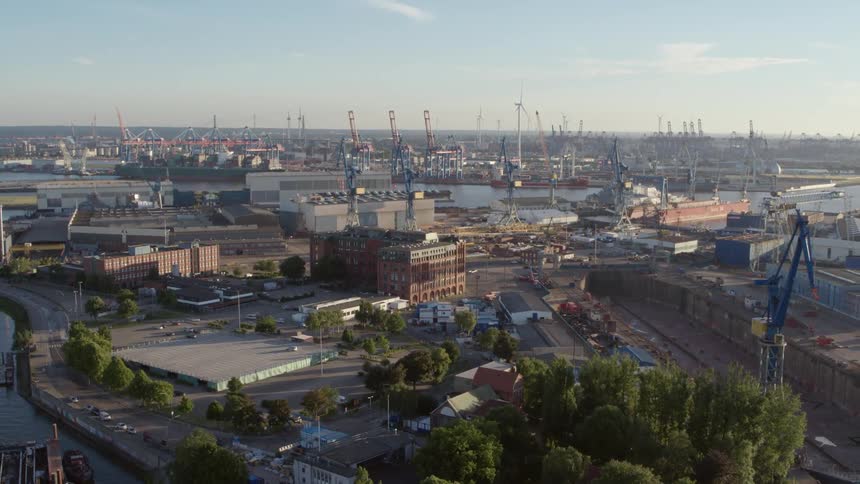 Buildings and trees sit under the blue sky - Hamburg Harbor
