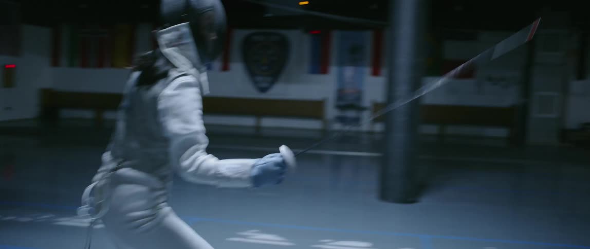 Woman in a fencing costume practices with her sword
