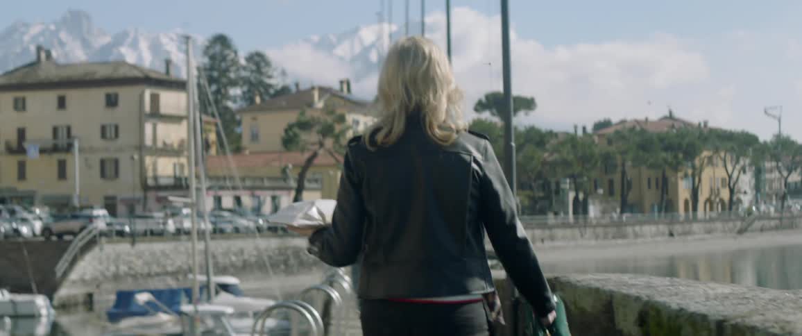 Two women walking near a small marina