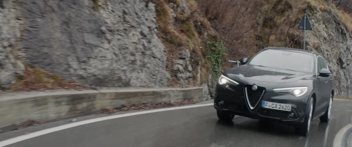 The car drives around the wet road