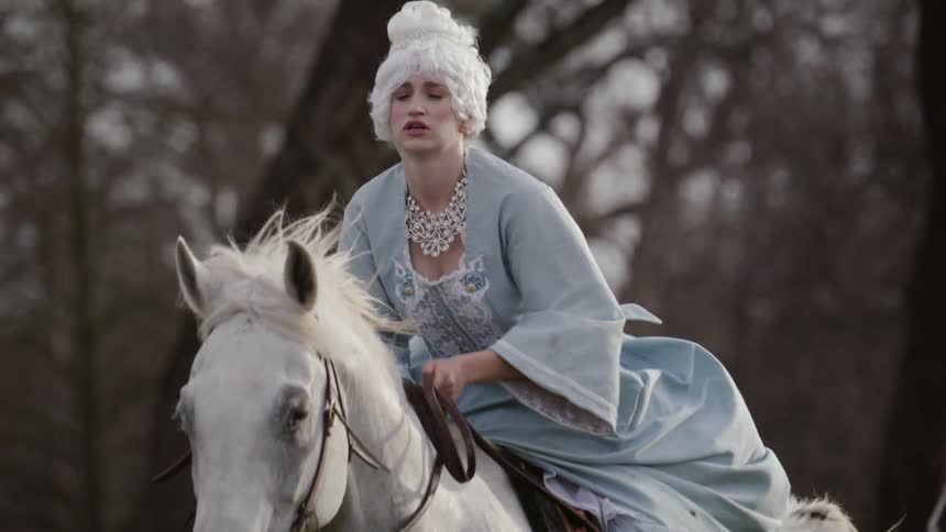 Woman in period costume rides horse