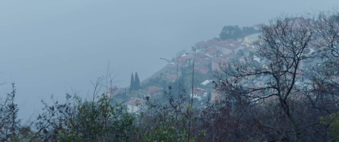 The hills ahead are covered with houses in the fog