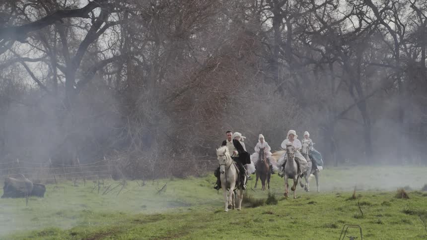 People in period costumes riding horses