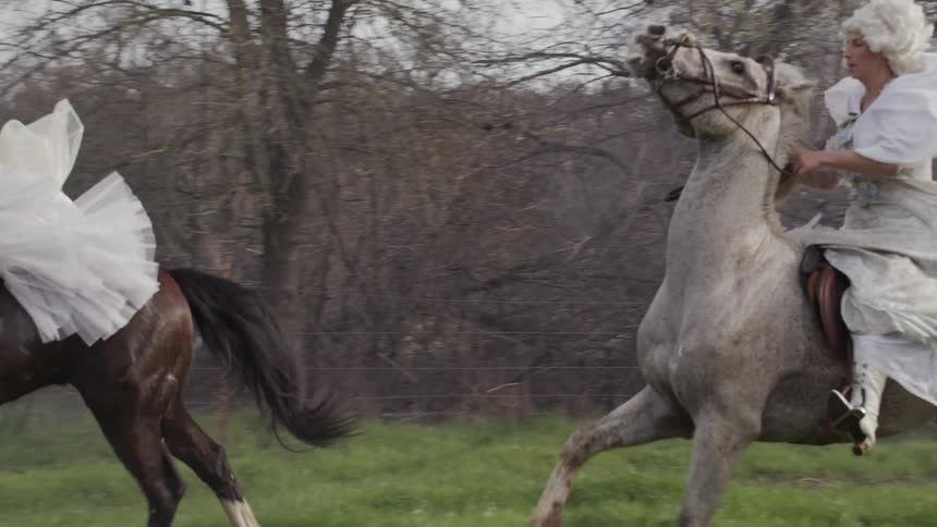 Man and women ride horses across a foggy field