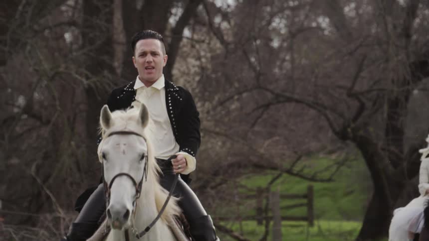 Man and woman in period costumes ride horses