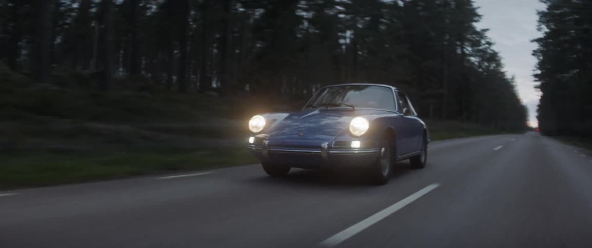 A blue sports car races on the road