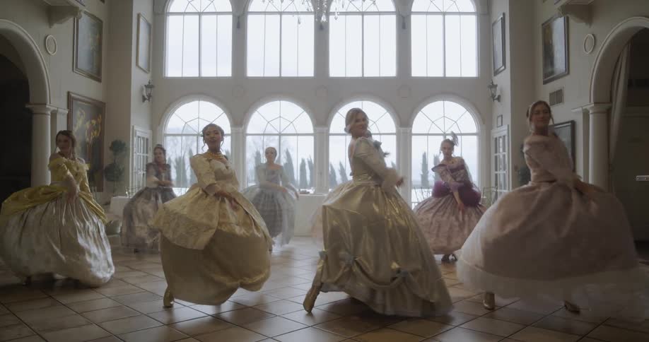 Women dancing in a hall wearing old fashioned dresses