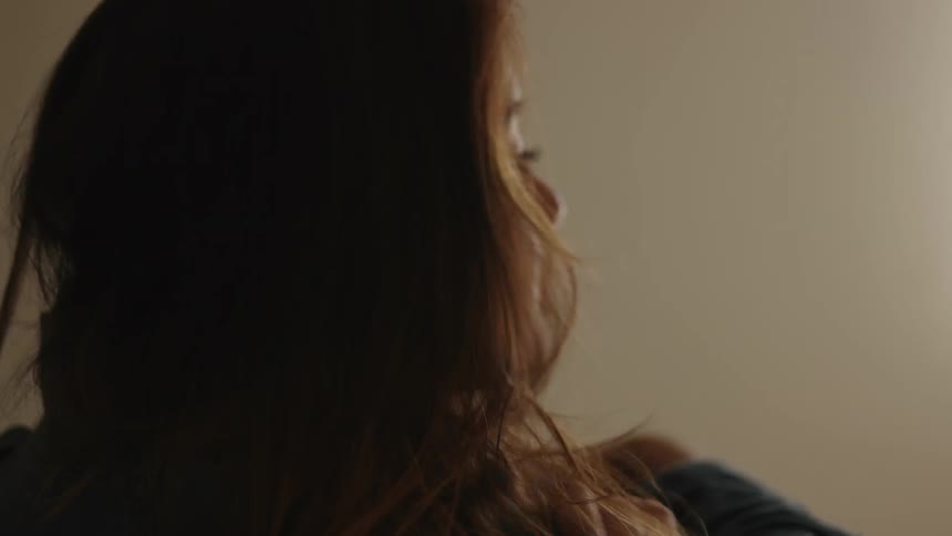 A brunette woman resting her chin on her arms
