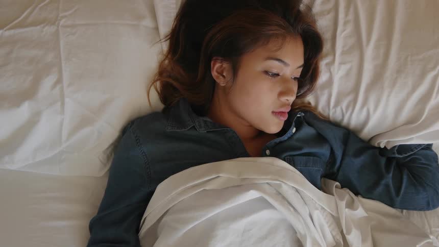 A woman lays in a bed